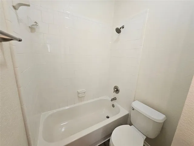 a white bath tub sitting next to a white toilet