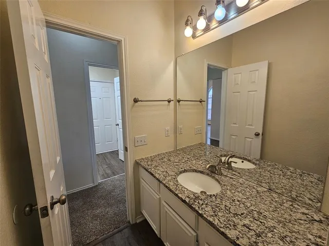 a bathroom with a granite countertop sink and a mirror