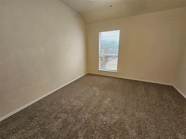 an empty room with a chandelier fan and closet