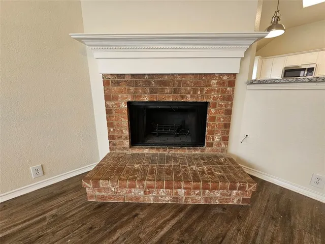 a view of empty room with wooden floor and fireplace