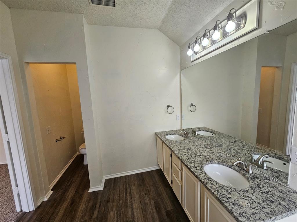 7851 Orland Park Circle Fort Worth, TX 76137 - Photo 31 of 35 a bathroom with a granite countertop sink a vanity and mirror