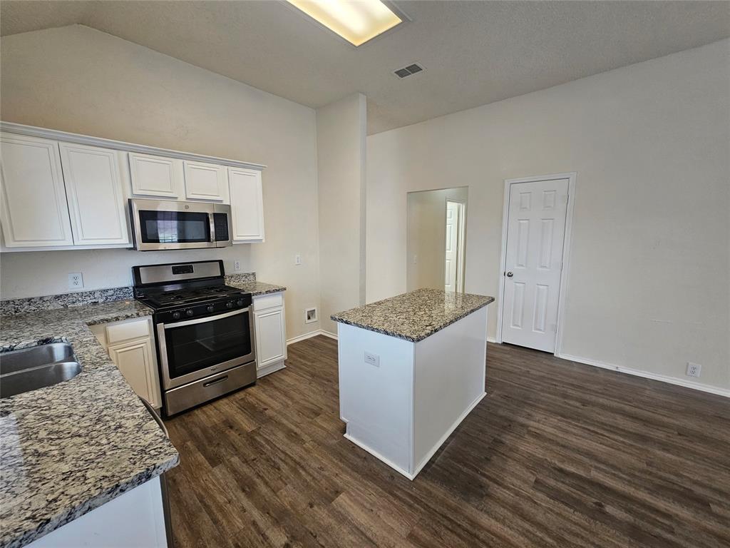 7851 Orland Park Circle Fort Worth, TX 76137 - Photo 7 of 35 a kitchen with granite countertop a stove and a microwave oven