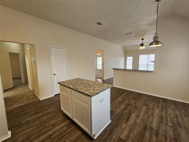 a open kitchen with cabinets stove and wooden floor