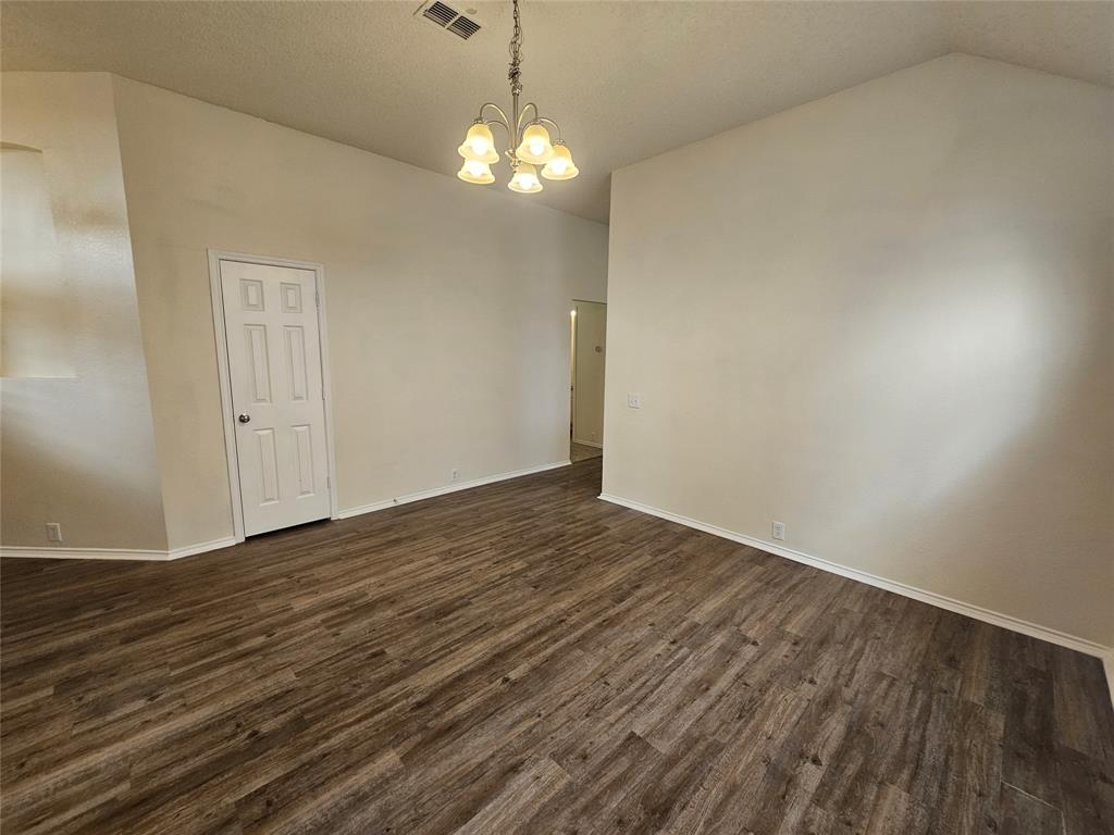7851 Orland Park Circle Fort Worth, TX 76137 - Photo 10 of 35 an empty room with wooden floor and chandelier