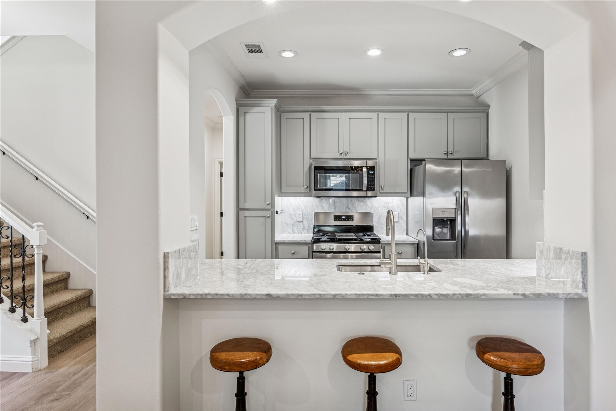 3303 Pecos Street, Unit B Austin, TX 78703 - Photo 11 of 30 a kitchen with stainless steel appliances granite countertop a sink a stove a refrigerator with white cabinets and wooden floor