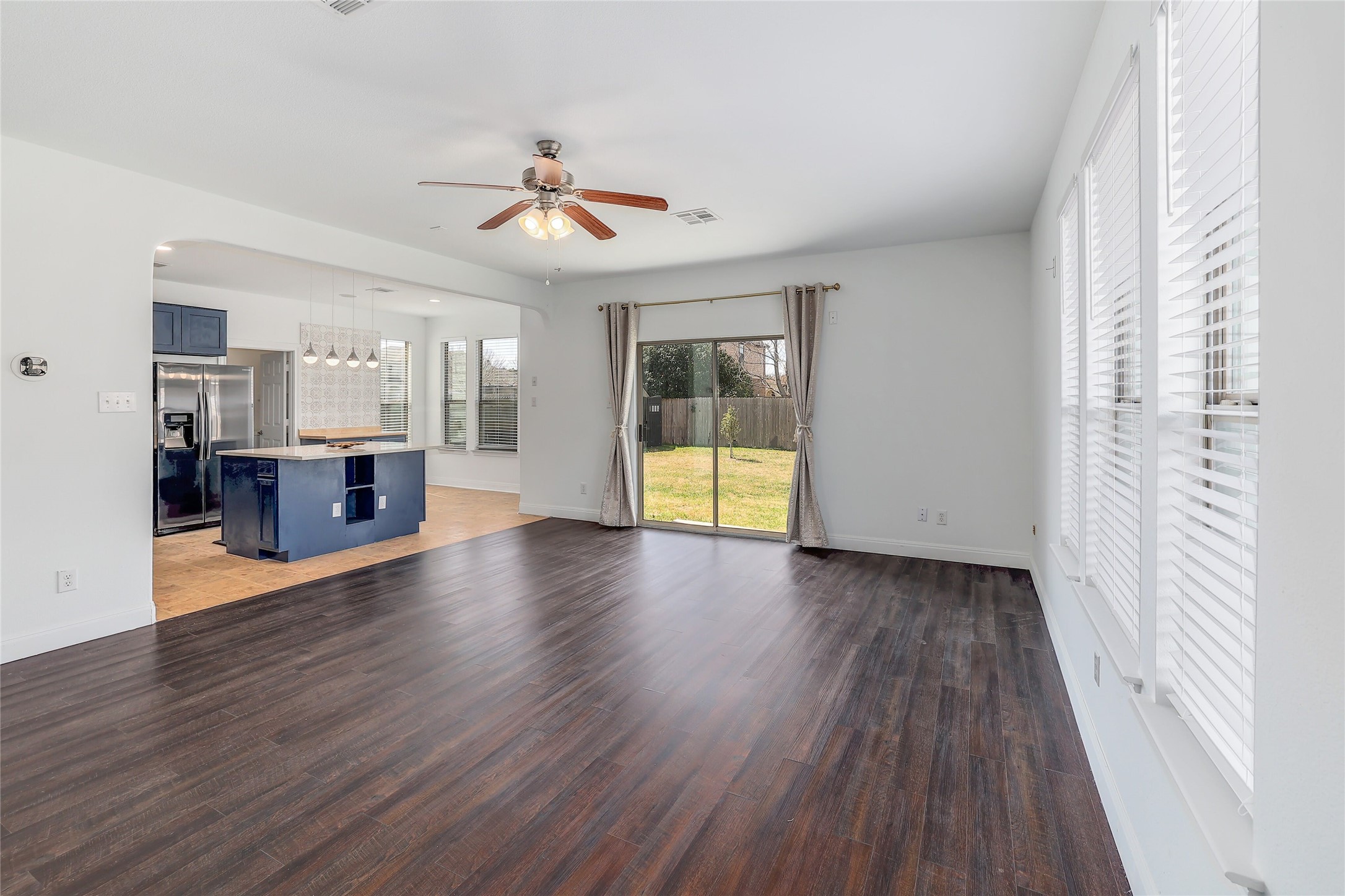 203 Ran Road Leander, TX 78641 - Photo 7 of 31 Rich wood-look flooring anchors this open living space, leading directly to the backyard.