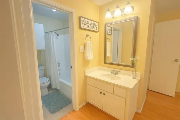 a bathroom with a granite countertop sink toilet and shower a mirror
