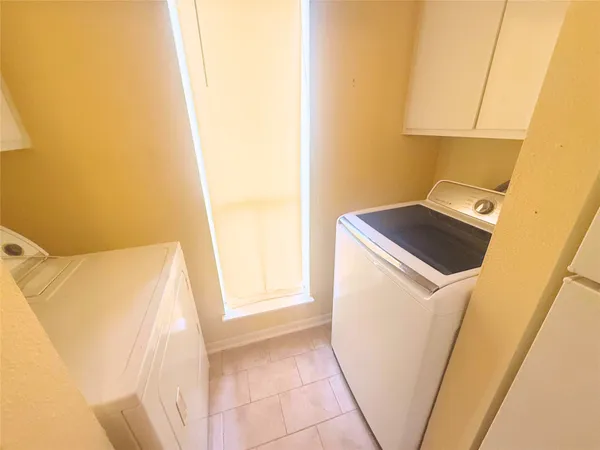 a utility room with wooden floor washer and dryer