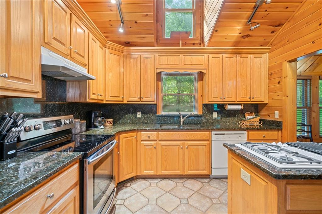 5 Tally Mountain Road North Jasper, GA 30143 - Photo 37 of 58 a kitchen with stainless steel appliances granite countertop a sink stove and granite countertops