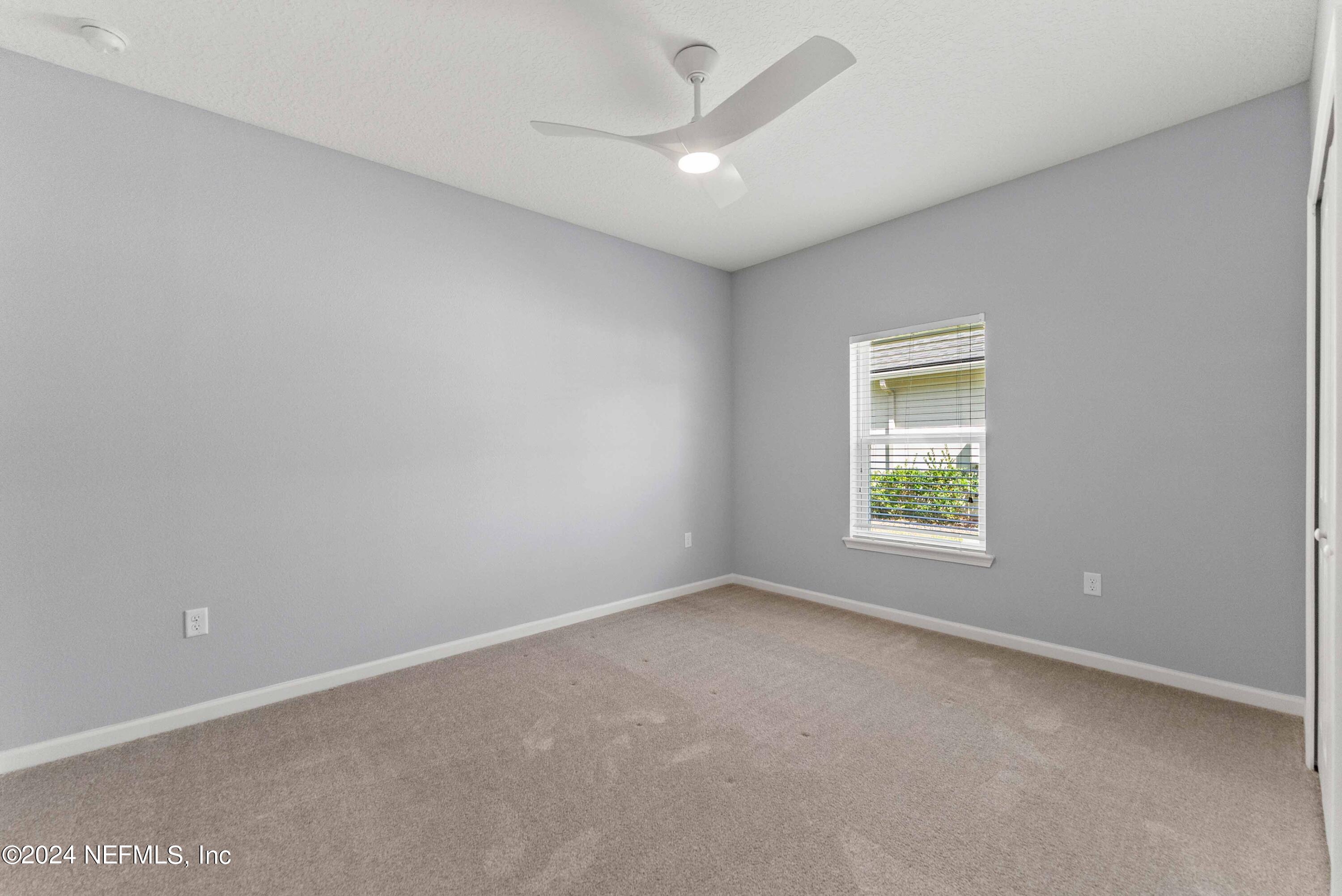 15 Greenview Lane St. Augustine, FL 32092 - Photo 21 of 41 an empty room with a chandelier fan and windows
