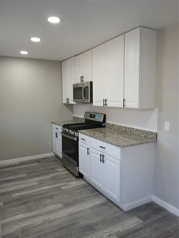 a kitchen with stainless steel appliances granite countertop a stove a sink and a white refrigerator