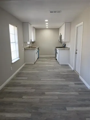 a view of a kitchen with sink microwave and cabinets