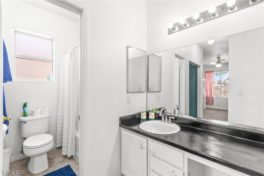 7353 Ridge Star Court Las Vegas, NV 89131 - Photo 26 of 36 A compact bathroom offers functionality with a vanity, mirrored cabinets, and a convenient window.