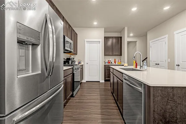 a kitchen with stainless steel appliances granite countertop a refrigerator and a sink