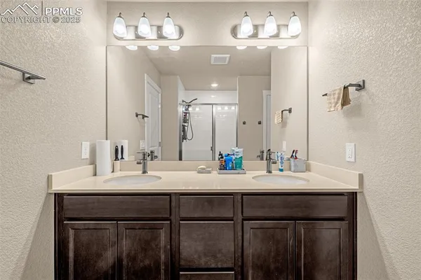 a bathroom with a sink vanity a mirror and a light fixture