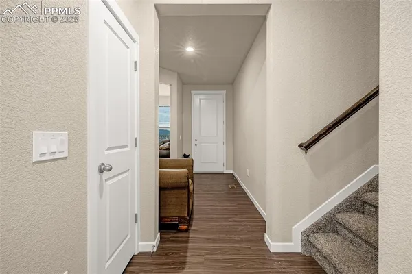 a view of a hallway with wooden floor and staircase