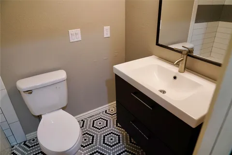 a bathroom with a toilet sink and mirror