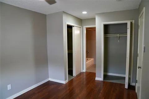 a view of an empty room with closet and a window