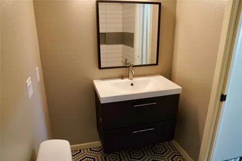 a bathroom with a sink toilet and mirror