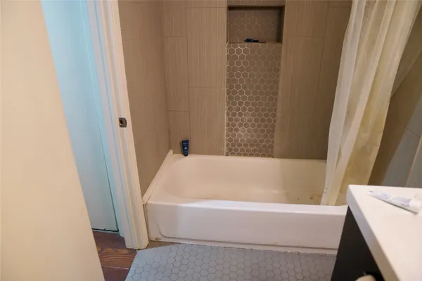 a bathroom with bathtub and shower