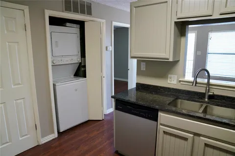 a kitchen with granite countertop white cabinets and sink