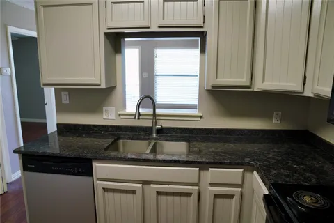 a kitchen with granite countertop a sink and a stove