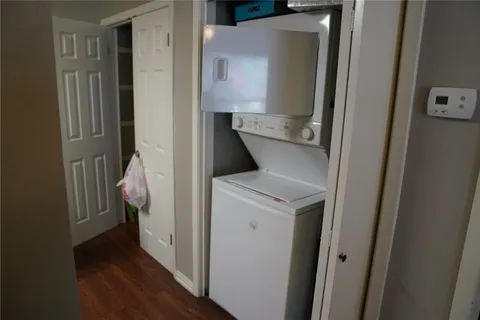 a utility room with wooden floor washer and dryer