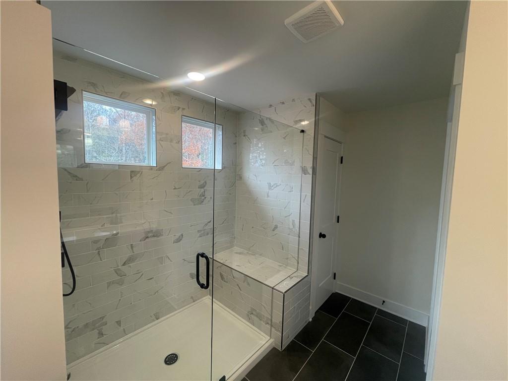131 Marble Tree Way Ball Ground, GA 30107 - Photo 12 of 13 a bathroom with a glass shower door