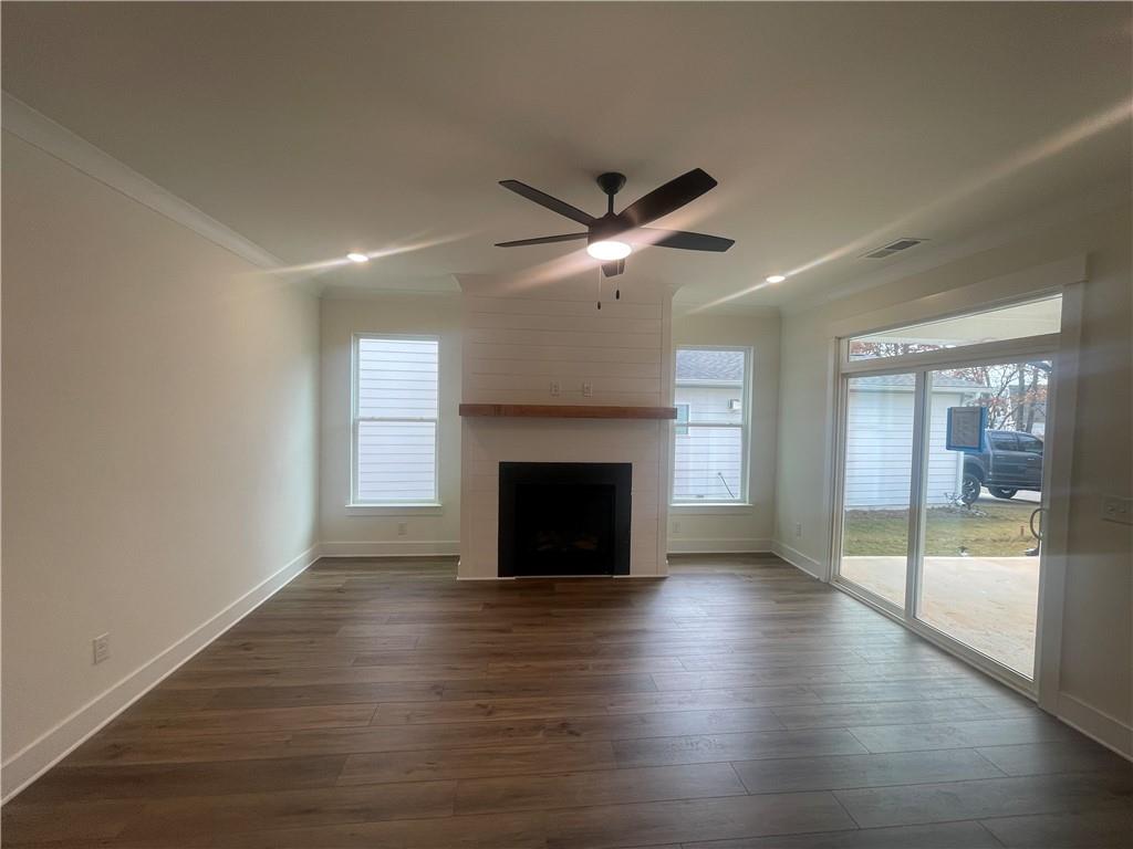 131 Marble Tree Way Ball Ground, GA 30107 - Photo 5 of 13 an empty room with wooden floor a fireplace and windows
