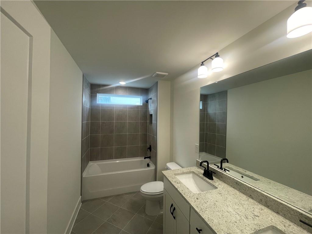 131 Marble Tree Way Ball Ground, GA 30107 - Photo 7 of 13 a bathroom with a granite countertop sink toilet mirror and bathtub