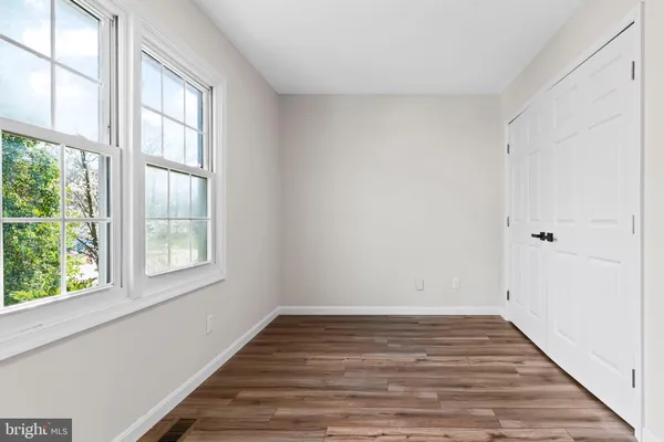 a view of an empty room with closet and a window