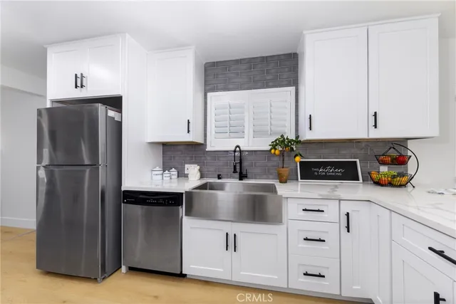 a kitchen with white cabinets and refrigerator