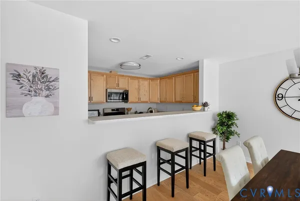 a kitchen with stainless steel appliances a white table chairs and a refrigerator