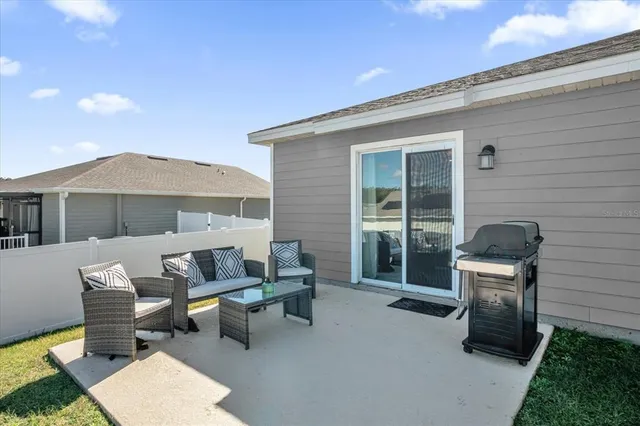 a patio with couches and a potted plant on the table