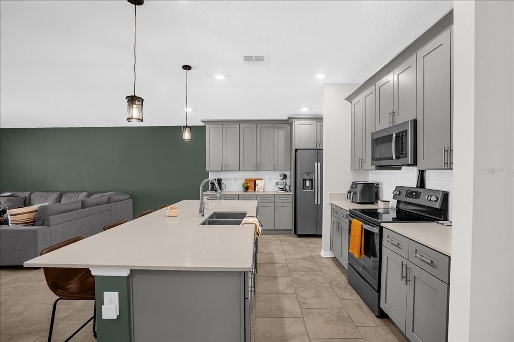 5317 Travertine St Mount Mount Dora, FL 32757 - Photo 19 of 35 a kitchen with granite countertop a sink a counter top space stainless steel appliances and cabinets