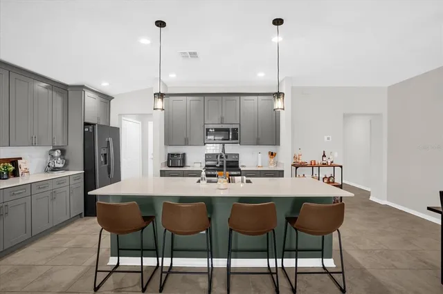 a kitchen with refrigerator and chairs