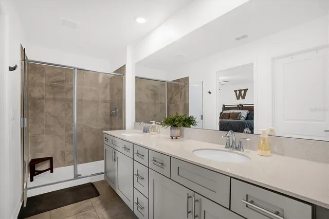a bathroom with a double vanity sink toilet and shower