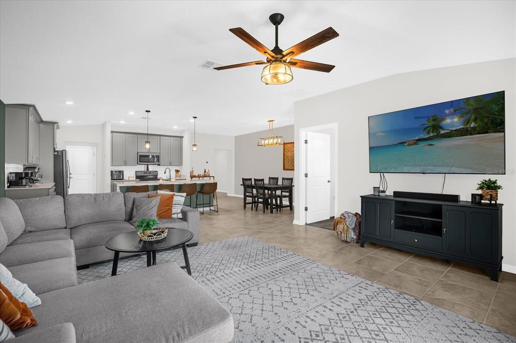 5317 Travertine St Mount Mount Dora, FL 32757 - Photo 3 of 35 a living room with furniture kitchen view and a flat screen tv
