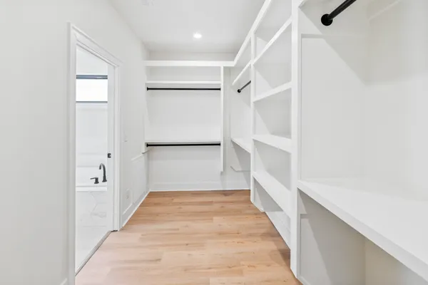 a kitchen with stainless steel appliances granite countertop a sink a stove a refrigerator and island with wooden floor