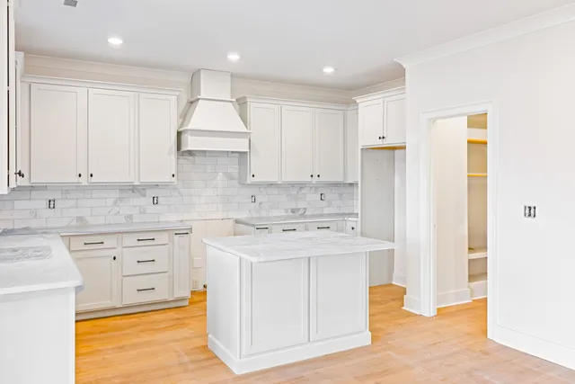 a kitchen with stainless steel appliances granite countertop a white stove top oven and white cabinets