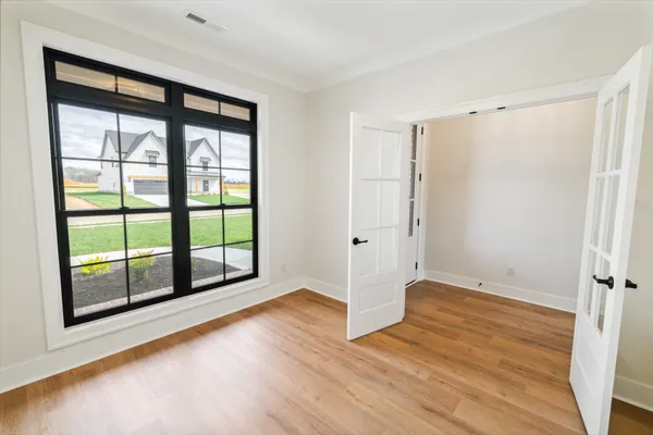 a view of an empty room with wooden floor