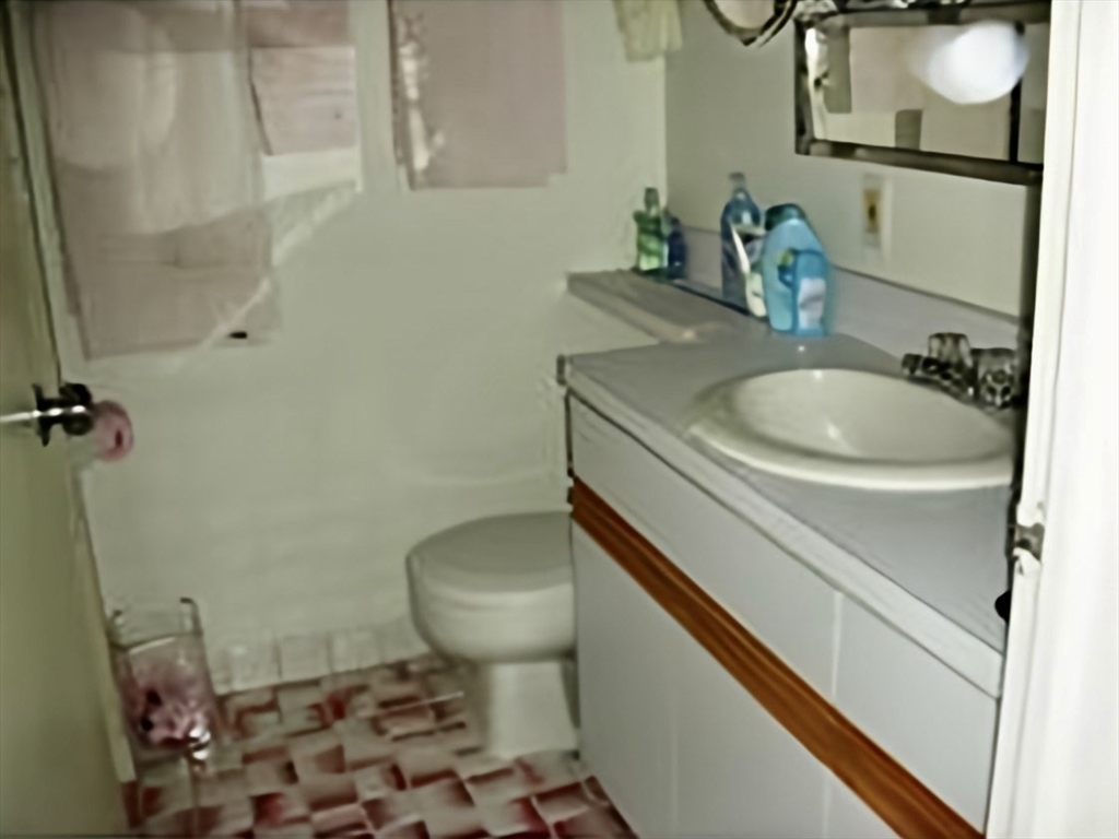 99 Pond Avenue, Unit 509 Brookline, MA 02445 - Photo 18 of 19 a bathroom with a sink toilet and mirror