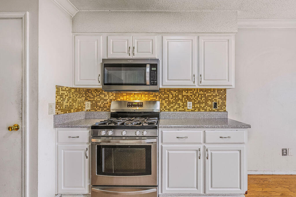 53 4th Street Shalimar, FL 32579 - Photo 17 of 47 a kitchen with white cabinets and appliances