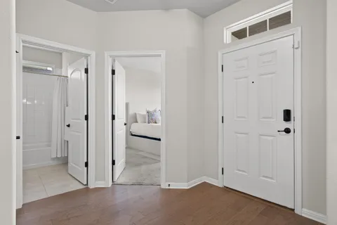 a view of a hallway with wooden floor windows and a living room