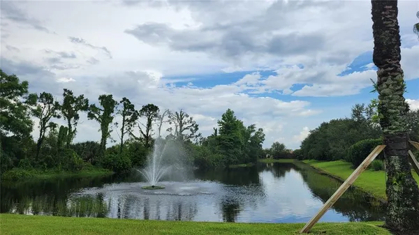 a front view of a house with a yard and fountain