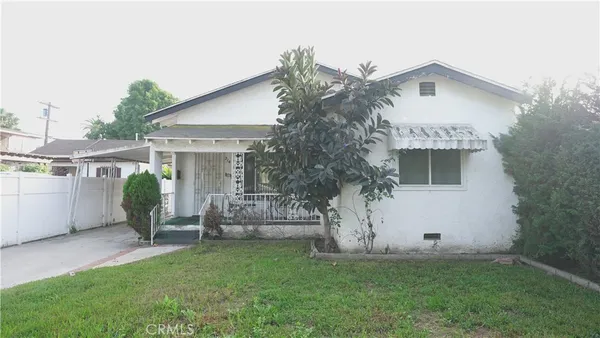 a view of a house with backyard and a tree