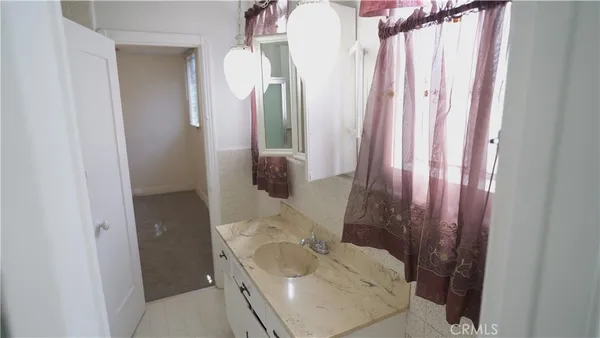 an empty room with a fan & a window