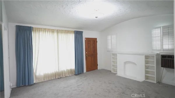 an empty room with fireplace and window