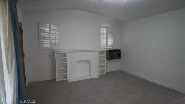 a view of a livingroom with an empty space and a window