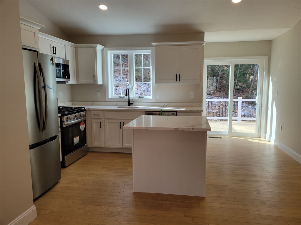 741 Chestnut Street Athol, MA 01331 - Photo 4 of 13 a kitchen with stainless steel appliances granite countertop a stove a sink dishwasher a refrigerator and a microwave oven with wooden floor